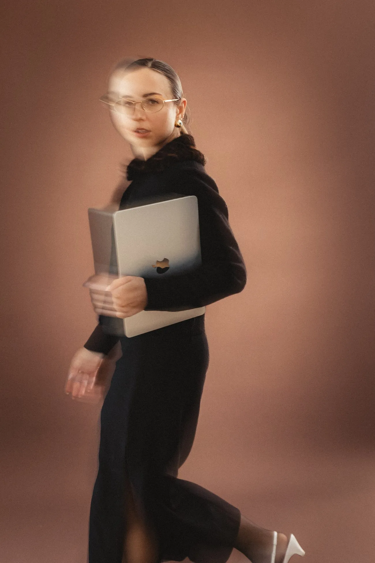 Nataliia Blinova photographed in motion against a warm studio backdrop